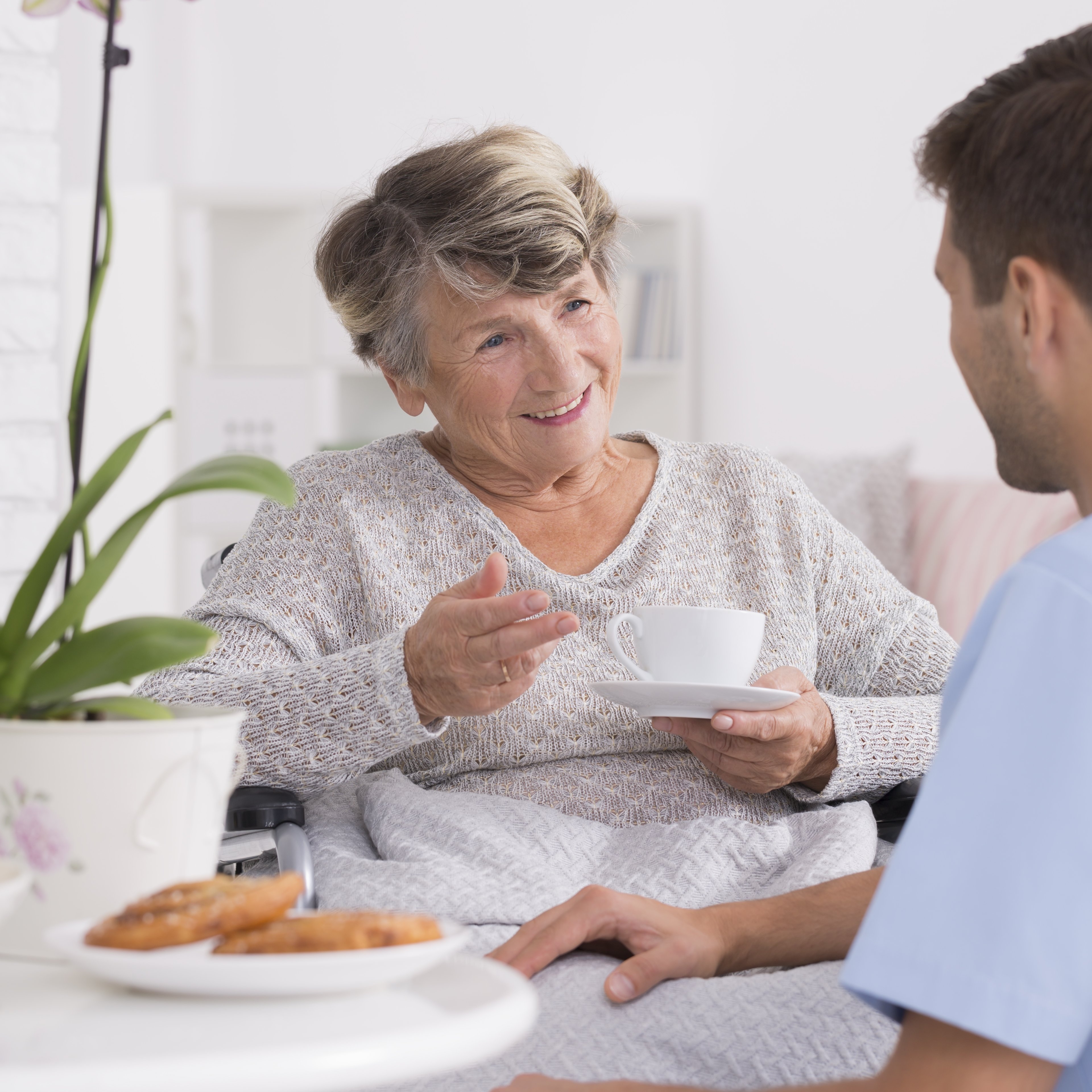 Grandmother talking with caregiver during tea time